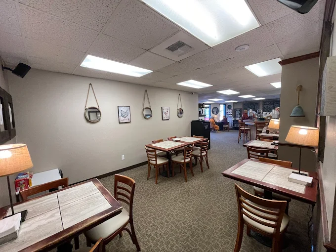 The cozy dining room at The Grind with tables and pendant lamps